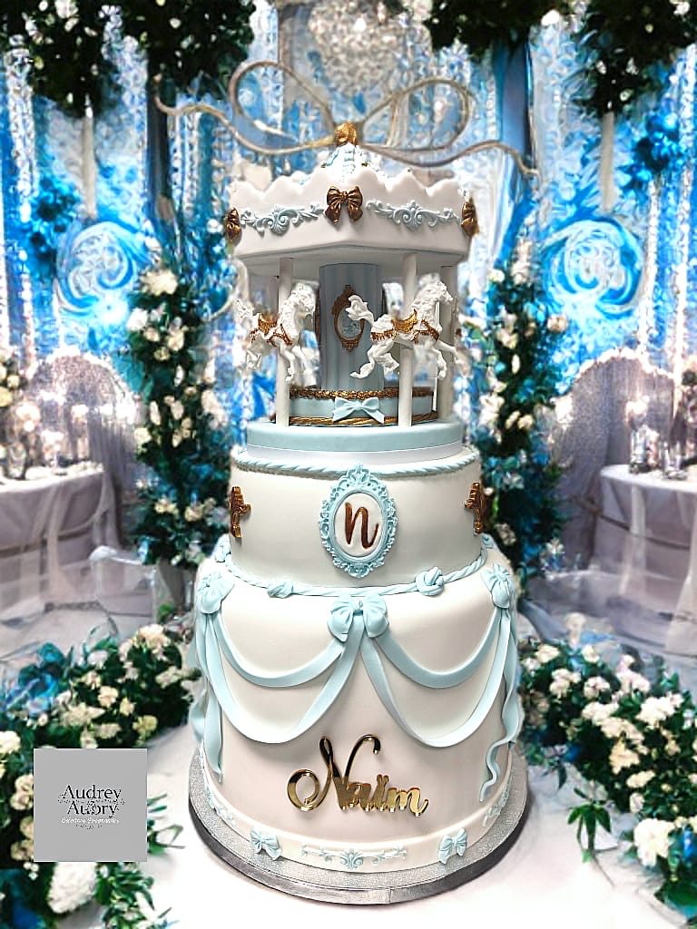 Gâteau de baptême carrousel bleu et or Naima — cake design Audrey Aubry