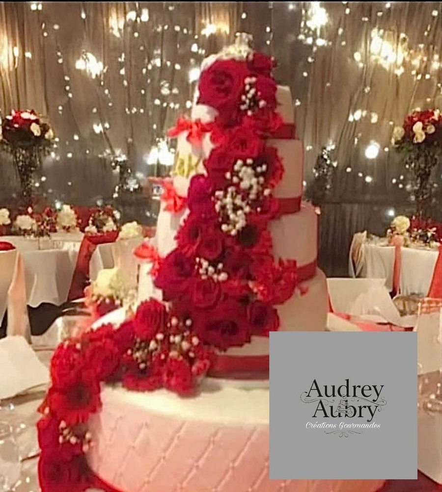 Gâteau de mariage blanc cascade de roses rouges — création Audrey Aubry Créations Gourmandes 2026